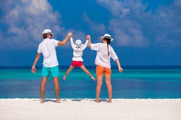 Familia joven en la playa blanca durante las vacaciones de verano