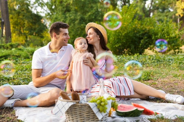 Familia joven positiva con niña pasar tiempo juntos