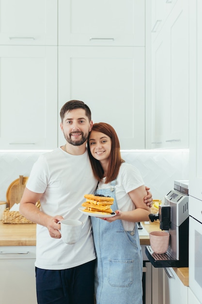 Familia joven preparando el desayuno juntos, marido y mujer feliz