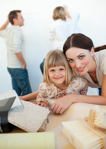 Familia joven que decora una habitación