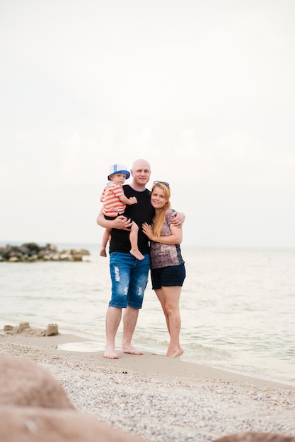 Una familia joven con su hijo caminando sobre el mar.