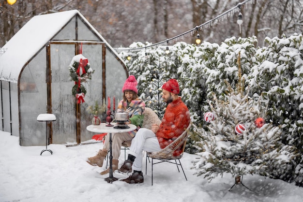 La familia joven tiene una cena romántica durante las vacaciones de invierno al aire libre