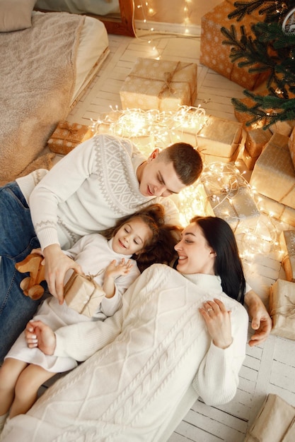 Familia joven tirada cerca del árbol de Navidad y celebrando juntos