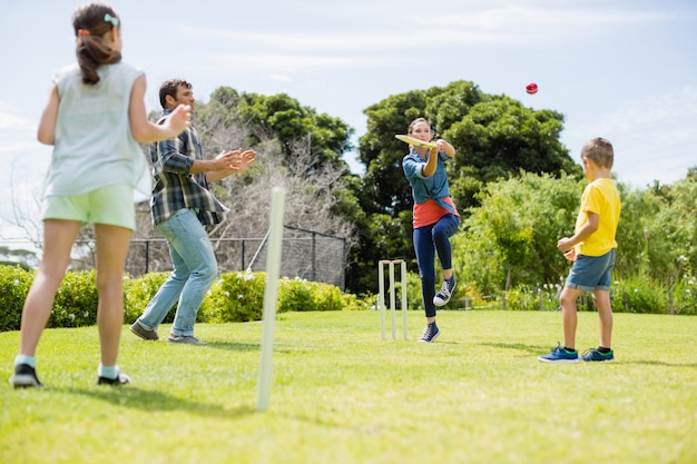 Familia jugando al cricket en el parque