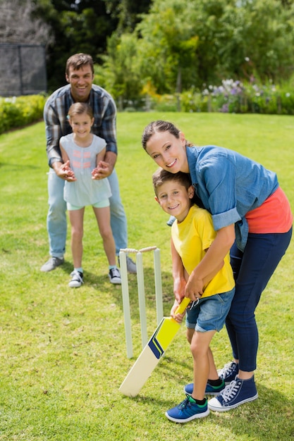 Familia jugando al cricket en el parque