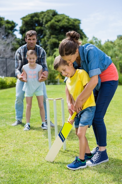 Familia jugando al cricket en el parque