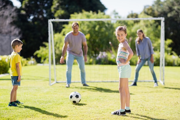 Familia jugando al fútbol juntos en el parque