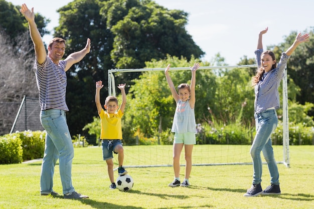 Familia jugando al fútbol juntos en el parque