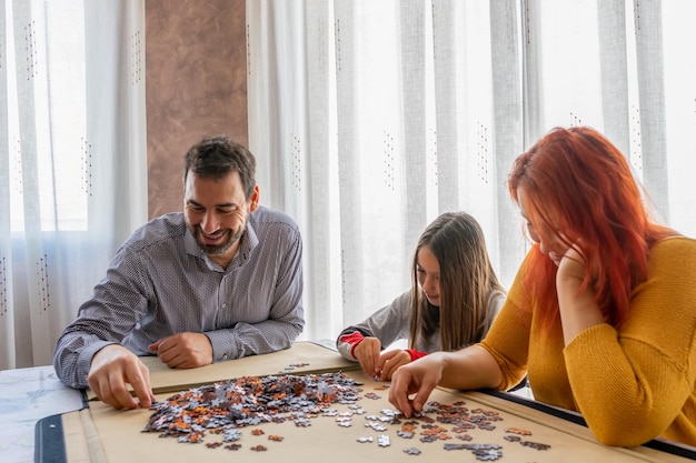 Foto familia jugando al rompecabezas en casa