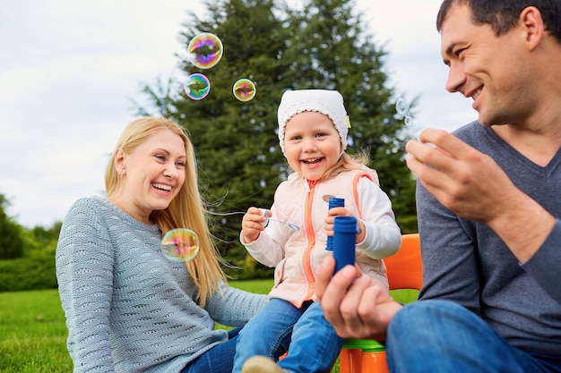 Familia jugando con burbujas al aire libre