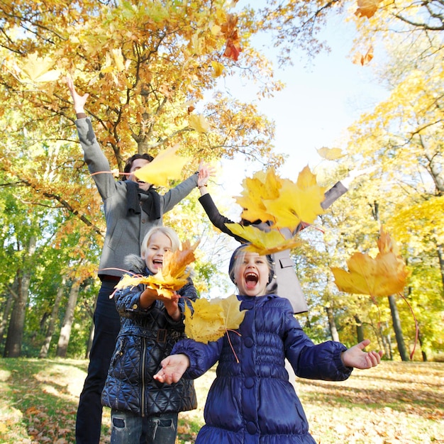 Familia jugando con hojas de otoño