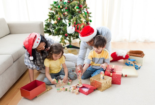 Familia jugando con regalos de Navidad en casa