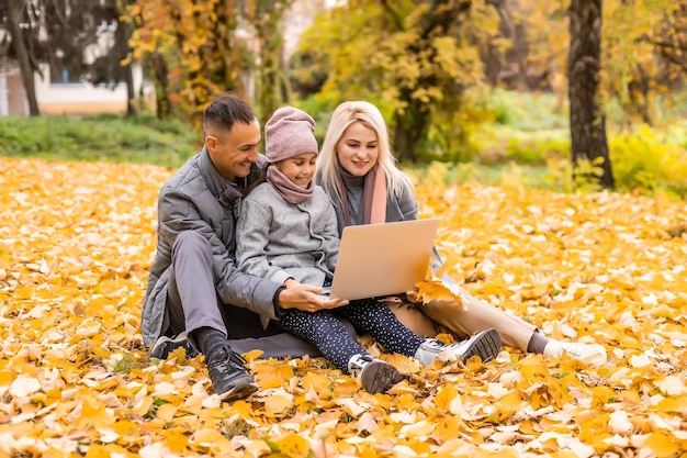 Familia con laptop en un día de otoño