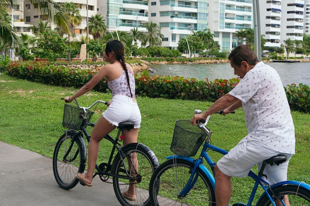 Família latina andando de bicicleta no parque da cidade