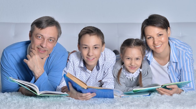 Familia leyendo libros juntos en el suelo