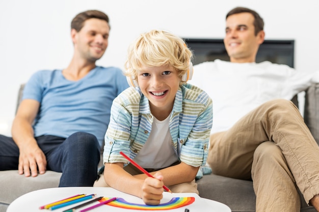 Familia LGBT, pareja gay con hijo adoptivo - Padres homosexuales con su hijo divirtiéndose en casa