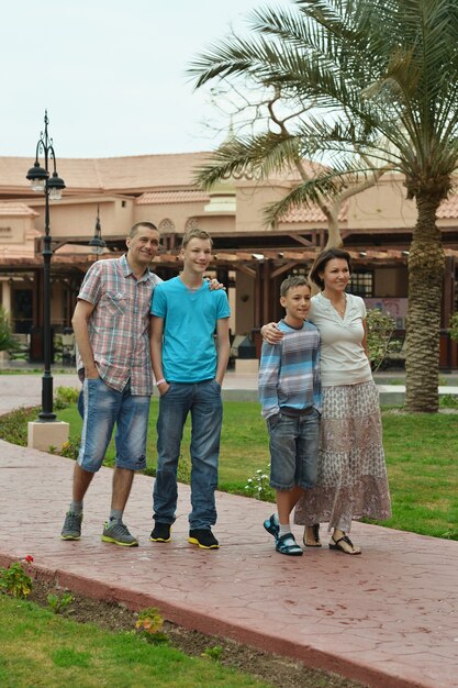 Família linda e feliz caminhando em um ressort tropical