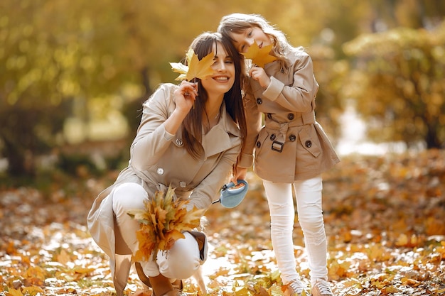 Familia linda y elegante en un parque de otoño