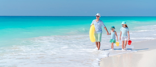 Família linda feliz em umas férias de praia tropical