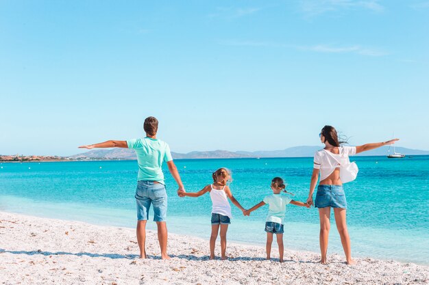 Família linda feliz na praia branca