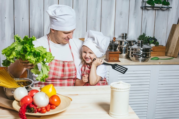 Família, linda filha pai em casa na cozinha rindo e preparando comida juntos