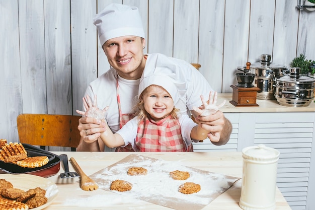 Família, linda filha pai em casa na cozinha rindo e preparando comida juntos