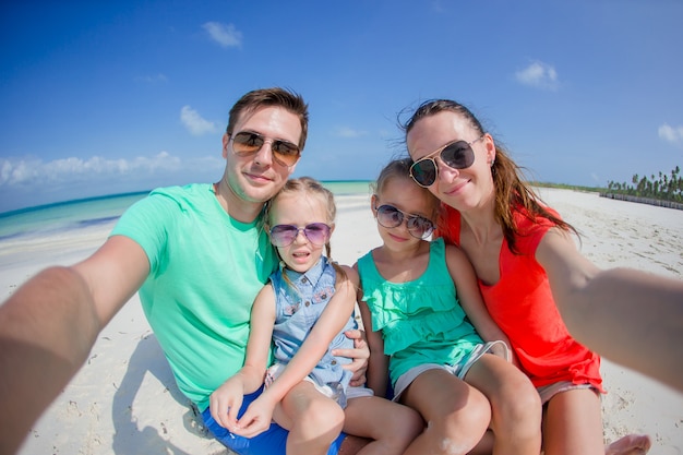 Família linda jovem tomando selfie na praia