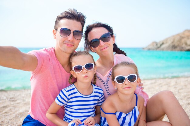 Família linda jovem tomando selfie na praia