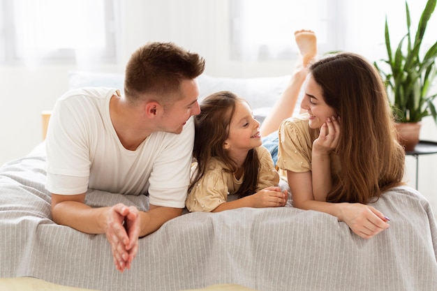 Família linda tendo um momento fofo juntos na cama