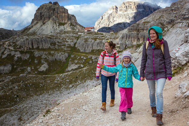 Foto familia - madre y dos hijas niñas hermanas excursionistas en las montañas dolomitas, italia. tre cime di lavaredo