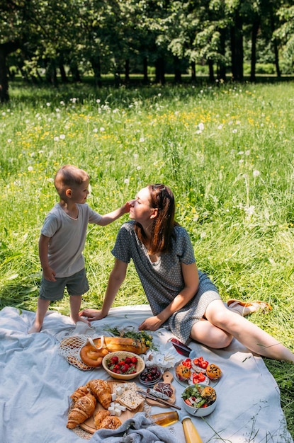 Familia madre e hijo en picnic Sonriendo y disfrutando el verano en una manta en el parque