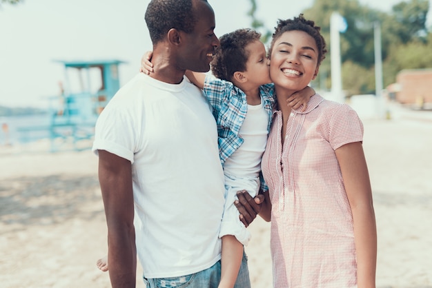 Familia de madre, padre e hijo en la playa.