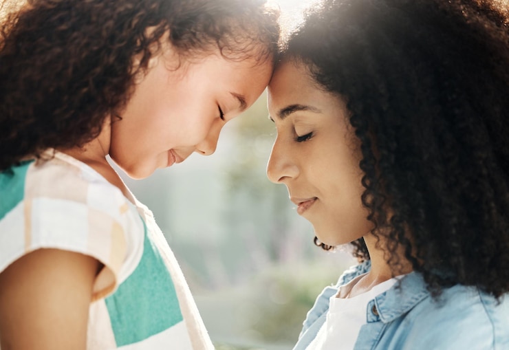 Foto família mãe e filho com amor e paz testa ao ar livre tocando com abraço calma e conteúdo relacionamento confiança e apoio mulher negra e menina maternidade e paternidade com conexão