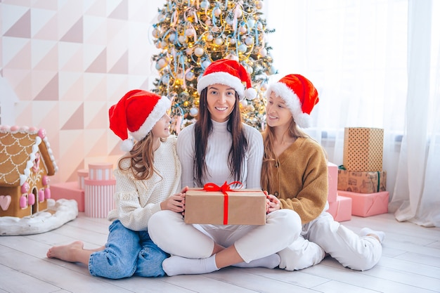 Familia de mamá e hijos con regalos en Navidad.