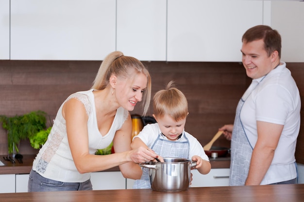 Familia mamá hijo papá están preparando deliciosa comida en la cocina Mamá enseña