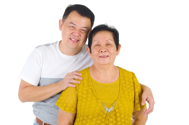 Familia mayor feliz de la familia asiática y descendencia adulta que tiene tiempo de la diversión en el estudio interior.