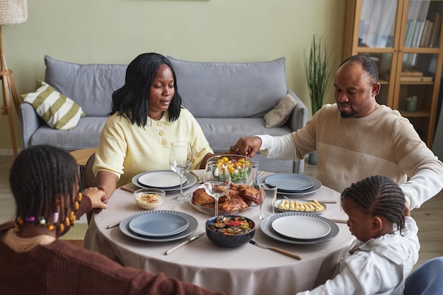 Familia meditando juntos antes de la cena