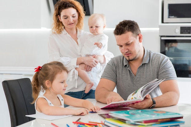 Foto familia mirando el libro para niños