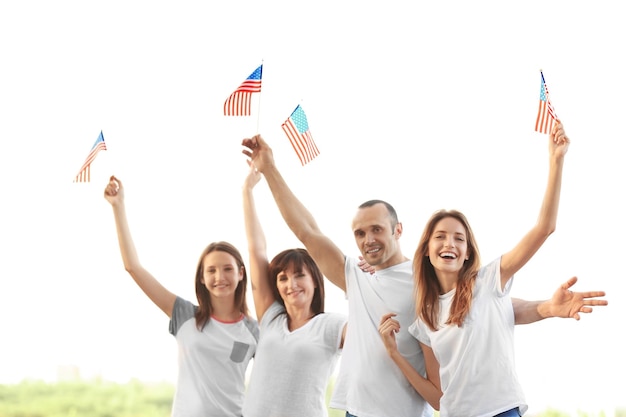 Família moderna com bandeiras dos EUA ao ar livre