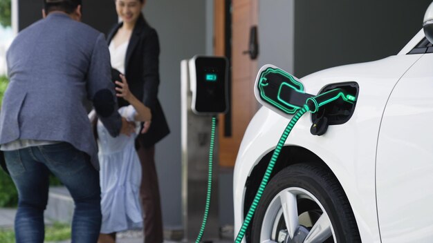 Família moderna com menina recarrega carro elétrico carregador EV de estação de carregamento em casa conectado a carro elétrico na garagem da casa infraestrutura de energia doméstica inteligente e futurista Peruse