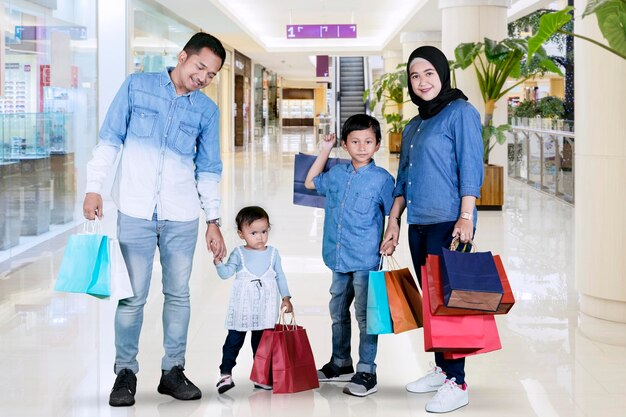 Família muçulmana com sacolas de compras no shopping