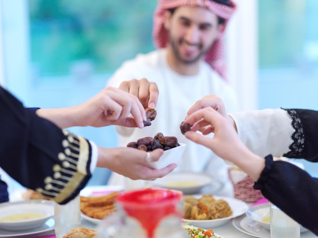 Família muçulmana de Eid Mubarak jantando Iftar comendo tâmaras para quebrar a festa. Comendo comida tradicional durante o mês de festa do Ramadã em casa. O Islã Halal Comer e Beber no Islã Ocidental Moderno