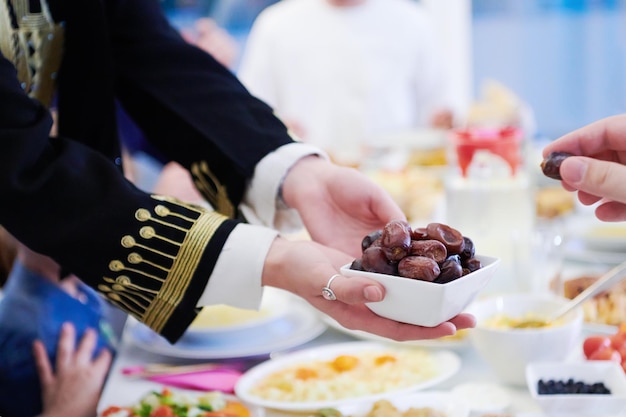 Família muçulmana de Eid Mubarak jantando Iftar comendo tâmaras para quebrar a festa. Comendo comida tradicional durante o mês de festa do Ramadã em casa. O Islã Halal Comer e Beber no Islã Ocidental Moderno