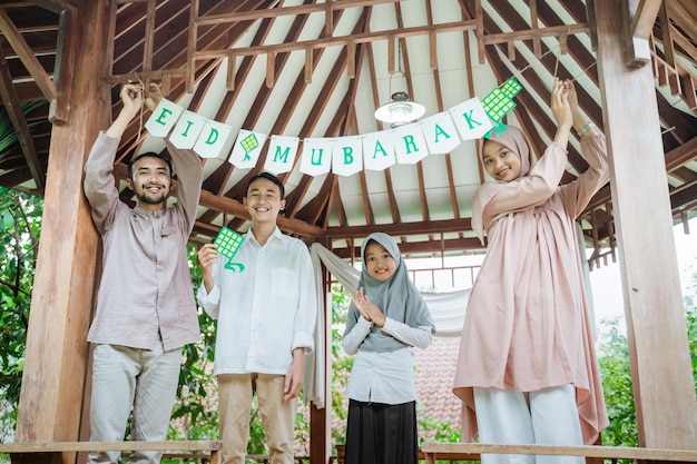 Família muçulmana junto coloca decorações de papel no gazebo