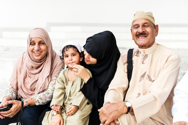 Família muçulmana sentados juntos ao ar livre