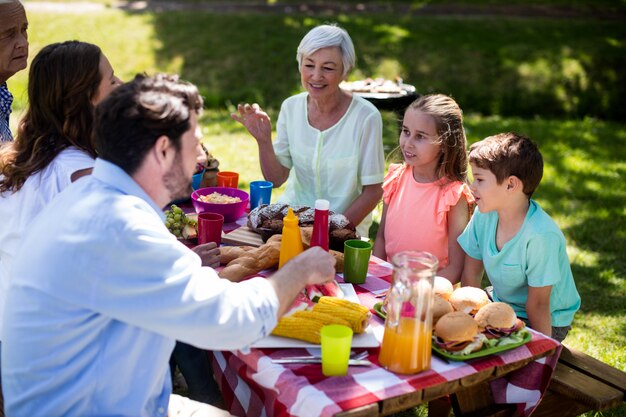 Familia multigeneración feliz que tiene comida en la mesa