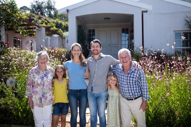 Familia multigeneración parada en el camino del jardín