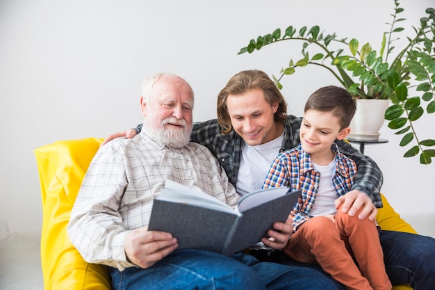 Foto familia multigeneracional mirando a través del antiguo álbum de fotos.