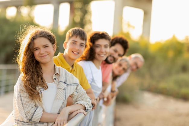 Família multigeracional europeia sorridente se diverte aproveitando as férias no parque da cidade no fim de semana