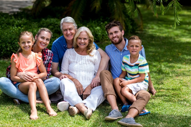 Familia de múltiples generaciones descansando en el césped en el patio